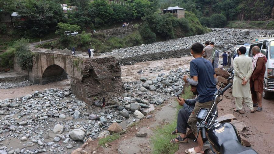 Orang-orang berkumpul di lokasi banjir bandang di Tehsil Salarzai di distrik Bajaur, Pakistan. Korban jiwa akibat hujan monsun deras yang memicu tanah longsor dan banjir bandang di wilayah utara Pakistan terus bertambah. Hingga Sabtu, 16 Agustus 2025, sedikitnya 194 orang dilaporkan meninggal. (REUTERS/Stringer)