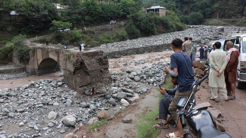 Orang-orang berkumpul di lokasi banjir bandang di Tehsil Salarzai di distrik Bajaur, Pakistan. Korban jiwa akibat hujan monsun deras yang memicu tanah longsor dan banjir bandang di wilayah utara Pakistan terus bertambah. Hingga Sabtu, 16 Agustus 2025, sedikitnya 194 orang dilaporkan meninggal. (REUTERS/Stringer)