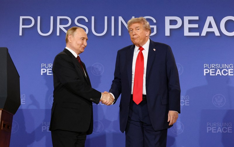 Presiden AS Donald Trump dan Presiden Rusia Vladimir Putin berjabat tangan dalam konferensi pers setelah pertemuan mereka untuk merundingkan akhir perang di Ukraina, di Pangkalan Gabungan Elmendorf-Richardson, di Anchorage, Alaska, AS, 15 Agustus 2025. (REUTERS/Kevin Lamarque)