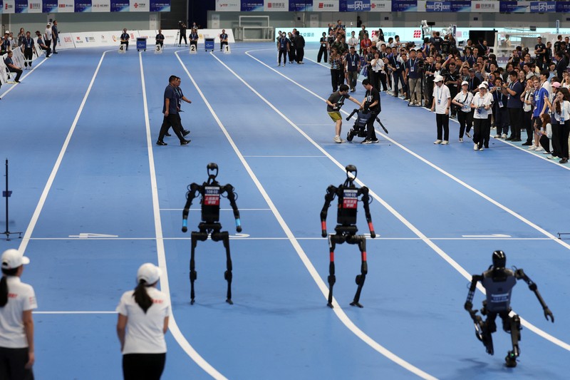 CHINA-ROBOTS/GAMES Unitree Robotics and Tiangong humanoid robots compete in the 100m final at the inaugural World Humanoid Robot Games, at the National Speed Skating Oval in Beijing, China August 17, 2025. REUTERS/Florence Lo TPX IMAGES OF THE DAY