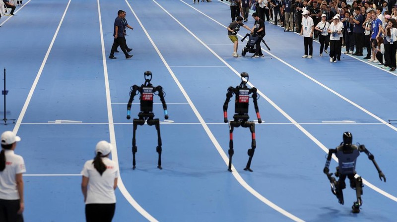 Unitree Robotics and Tiangong humanoid robots compete in the 100m final at the inaugural World Humanoid Robot Games, at the National Speed Skating Oval in Beijing, China August 17, 2025.  REUTERS/Florence Lo     TPX IMAGES OF THE DAY