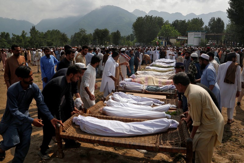 Seorang pria duduk di samping rumah-rumah yang rusak akibat hujan lebat dan banjir di distrik Buner di provinsi Khyber Pakhtunkhwa, Pakistan, 16 Agustus 2025. (REUTERS/Stringer)