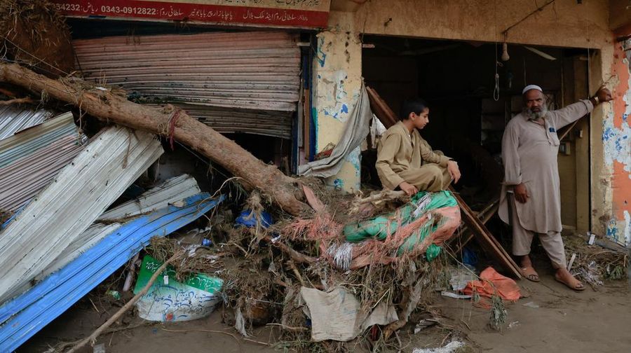 Seorang pria duduk di samping rumah-rumah yang rusak akibat hujan lebat dan banjir di distrik Buner di provinsi Khyber Pakhtunkhwa, Pakistan, 16 Agustus 2025. (REUTERS/Stringer)