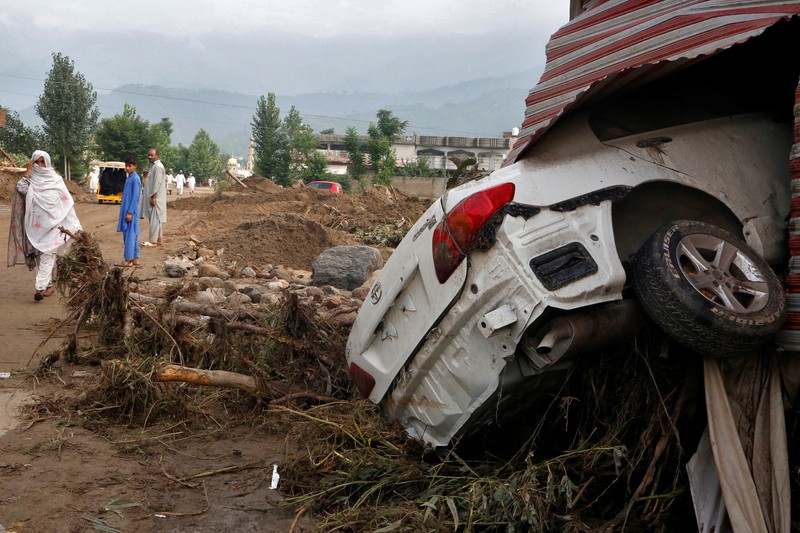 Seorang pria duduk di samping rumah-rumah yang rusak akibat hujan lebat dan banjir di distrik Buner di provinsi Khyber Pakhtunkhwa, Pakistan, 16 Agustus 2025. (REUTERS/Stringer)