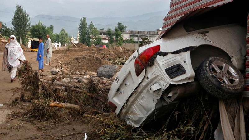 Seorang pria duduk di samping rumah-rumah yang rusak akibat hujan lebat dan banjir di distrik Buner di provinsi Khyber Pakhtunkhwa, Pakistan, 16 Agustus 2025. (REUTERS/Stringer)