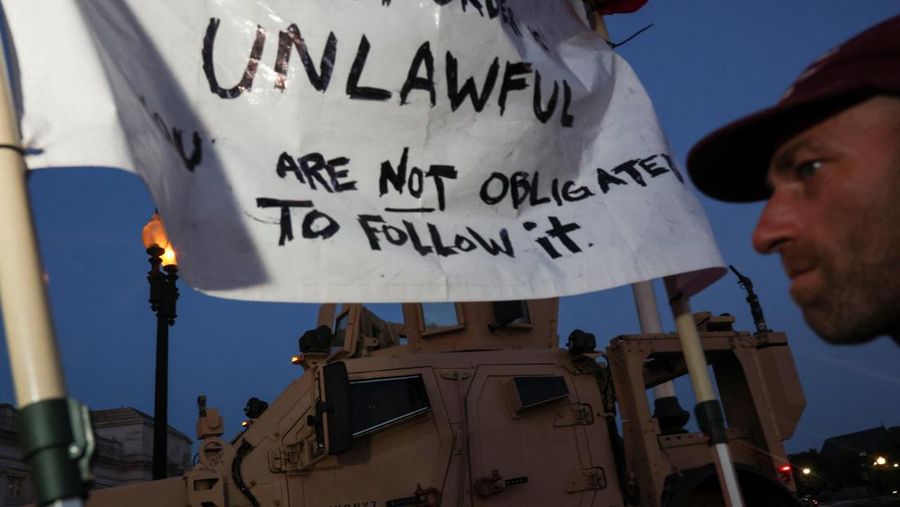 Banners, placed by demonstrators, hang on the White House fence during a protest after U.S. President Donald Trump deployed National Guard and ordered an increased presence of federal law enforcement to assist in crime prevention, in Washington, D.C., U.S., August 16, 2025. REUTERS/Ken Cedeno