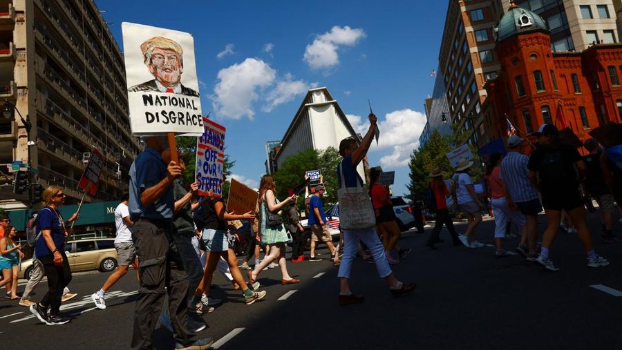 Banners, placed by demonstrators, hang on the White House fence during a protest after U.S. President Donald Trump deployed National Guard and ordered an increased presence of federal law enforcement to assist in crime prevention, in Washington, D.C., U.S., August 16, 2025. REUTERS/Ken Cedeno