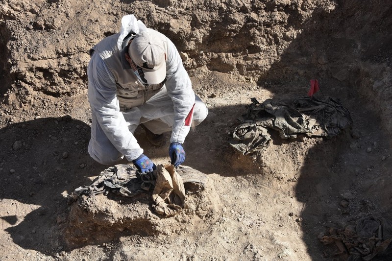 Tengkorak manusia ditandai dengan pita merah di situs Khasfa dekat kota Mosul di Irak utara, tempat pihak berwenang mulai menggali kuburan massal yang diyakini berisi ribuan korban ISIS, Minggu (17/8/2025). (AFP/ZAID AL-OBEIDI)