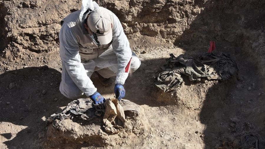 Tengkorak manusia ditandai dengan pita merah di situs Khasfa dekat kota Mosul di Irak utara, tempat pihak berwenang mulai menggali kuburan massal yang diyakini berisi ribuan korban ISIS, Minggu (17/8/2025). (AFP/ZAID AL-OBEIDI)