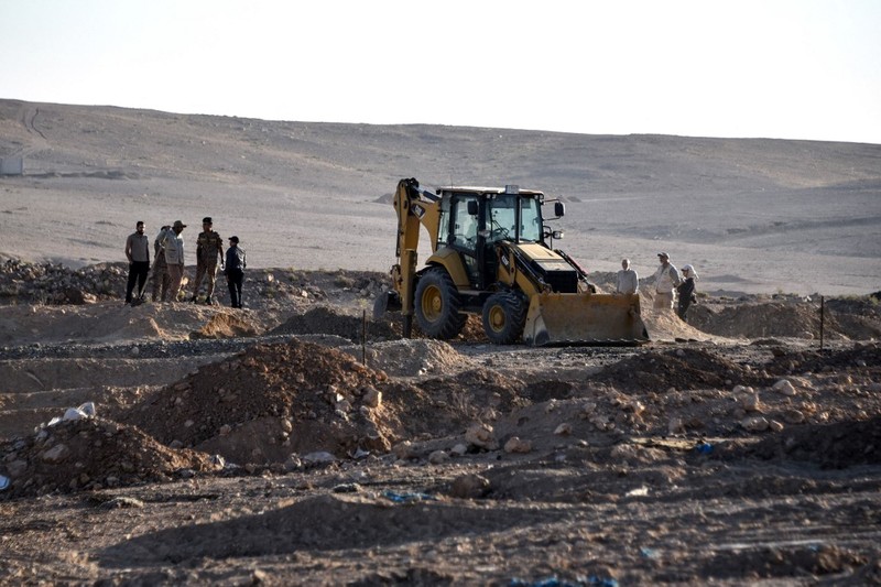 Tengkorak manusia ditandai dengan pita merah di situs Khasfa dekat kota Mosul di Irak utara, tempat pihak berwenang mulai menggali kuburan massal yang diyakini berisi ribuan korban ISIS. Tengkorak manusia ditandai dengan pita merah di situs Khasfa dekat kota Mosul di Irak utara, tempat pihak berwenang mulai menggali kuburan massal yang diyakini berisi ribuan korban ISIS, Minggu (17/8/2025). (AFP/ZAID AL-OBEIDI)