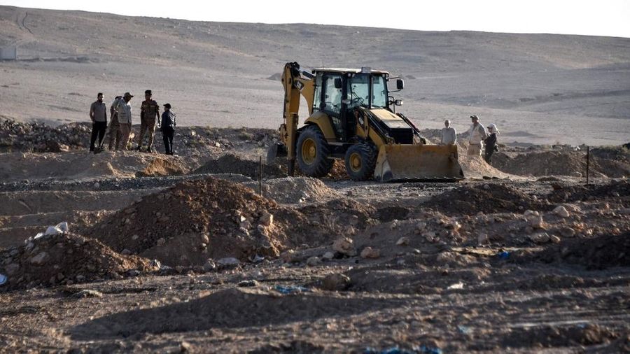 Tengkorak manusia ditandai dengan pita merah di situs Khasfa dekat kota Mosul di Irak utara, tempat pihak berwenang mulai menggali kuburan massal yang diyakini berisi ribuan korban ISIS, Minggu (17/8/2025). (AFP/ZAID AL-OBEIDI)