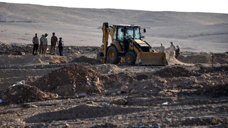Tengkorak manusia ditandai dengan pita merah di situs Khasfa dekat kota Mosul di Irak utara, tempat pihak berwenang mulai menggali kuburan massal yang diyakini berisi ribuan korban ISIS, Minggu (17/8/2025). (AFP/ZAID AL-OBEIDI)