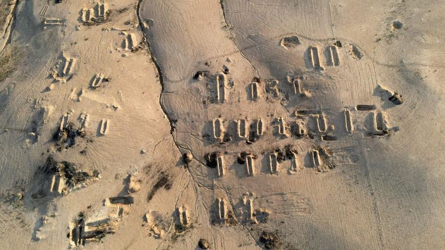 Tengkorak manusia ditandai dengan pita merah di situs Khasfa dekat kota Mosul di Irak utara, tempat pihak berwenang mulai menggali kuburan massal yang diyakini berisi ribuan korban ISIS, Minggu (17/8/2025). (AFP/ZAID AL-OBEIDI)