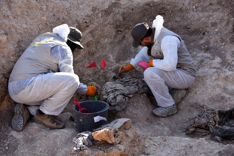 Tengkorak manusia ditandai dengan pita merah di situs Khasfa dekat kota Mosul di Irak utara, tempat pihak berwenang mulai menggali kuburan massal yang diyakini berisi ribuan korban ISIS. Tengkorak manusia ditandai dengan pita merah di situs Khasfa dekat kota Mosul di Irak utara, tempat pihak berwenang mulai menggali kuburan massal yang diyakini berisi ribuan korban ISIS, Minggu (17/8/2025). (AFP/ZAID AL-OBEIDI)