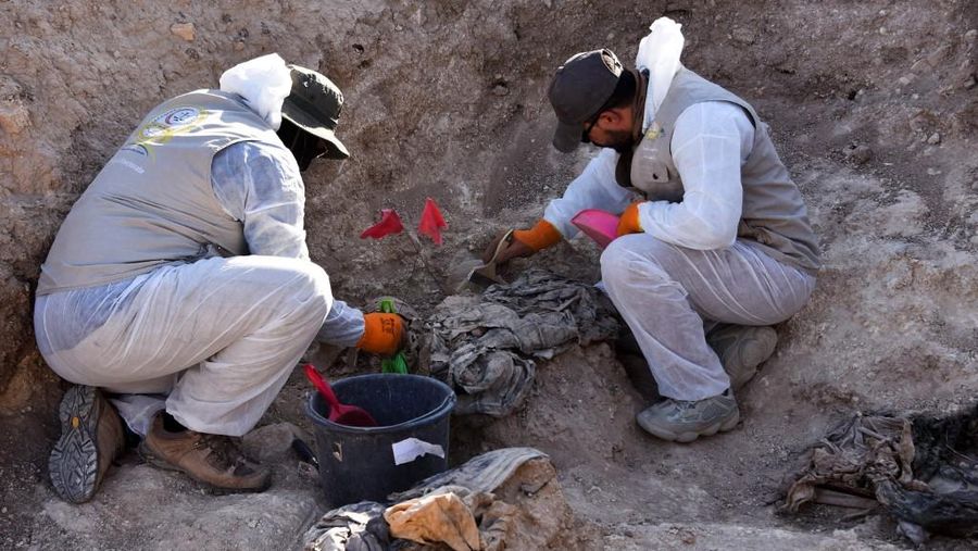 Tengkorak manusia ditandai dengan pita merah di situs Khasfa dekat kota Mosul di Irak utara, tempat pihak berwenang mulai menggali kuburan massal yang diyakini berisi ribuan korban ISIS. Tengkorak manusia ditandai dengan pita merah di situs Khasfa dekat kota Mosul di Irak utara, tempat pihak berwenang mulai menggali kuburan massal yang diyakini berisi ribuan korban ISIS, Minggu (17/8/2025). (AFP/ZAID AL-OBEIDI)