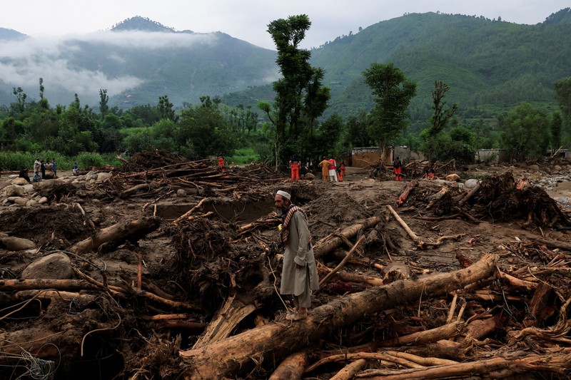 Warga duduk di antara puing-puing rumah yang rusak akibat badai yang menyebabkan hujan lebat dan banjir, di Bayshonai Kalay, distrik Buner, provinsi Khyber Pakhtunkhwa, Pakistan, 17 Agustus 2025. (REUTERS/Akhtar Soomro)