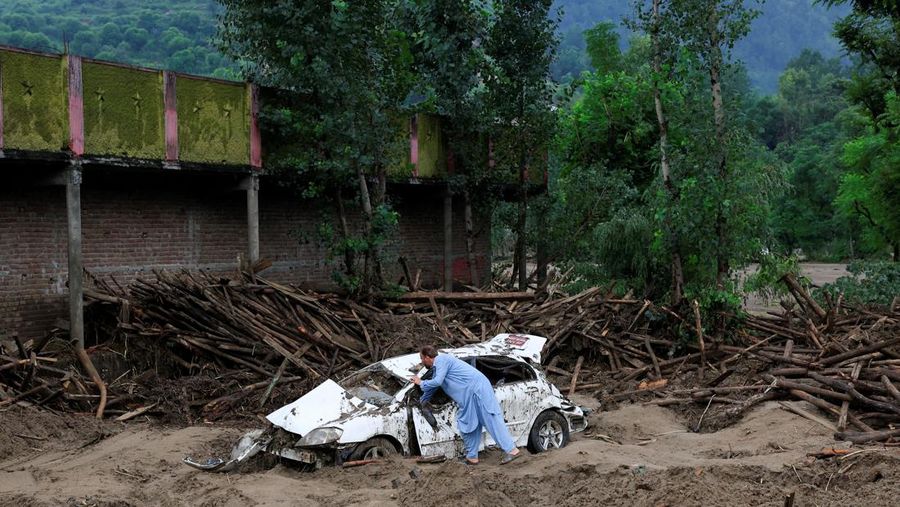 Warga duduk di antara puing-puing rumah yang rusak akibat badai yang menyebabkan hujan lebat dan banjir, di Bayshonai Kalay, distrik Buner, provinsi Khyber Pakhtunkhwa, Pakistan, 17 Agustus 2025. (REUTERS/Akhtar Soomro)