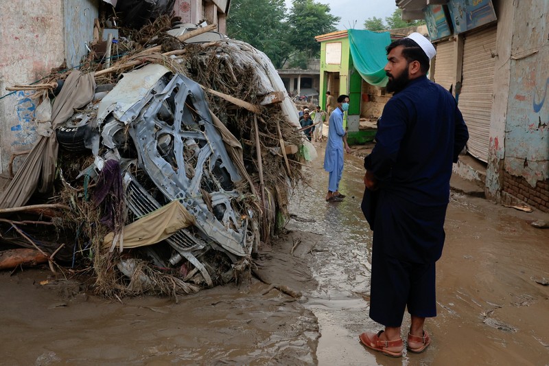 Warga duduk di antara puing-puing rumah yang rusak akibat badai yang menyebabkan hujan lebat dan banjir, di Bayshonai Kalay, distrik Buner, provinsi Khyber Pakhtunkhwa, Pakistan. Warga duduk di antara puing-puing rumah yang rusak akibat badai yang menyebabkan hujan lebat dan banjir, di Bayshonai Kalay, distrik Buner, provinsi Khyber Pakhtunkhwa, Pakistan, 17 Agustus 2025. (REUTERS/Akhtar Soomro)
