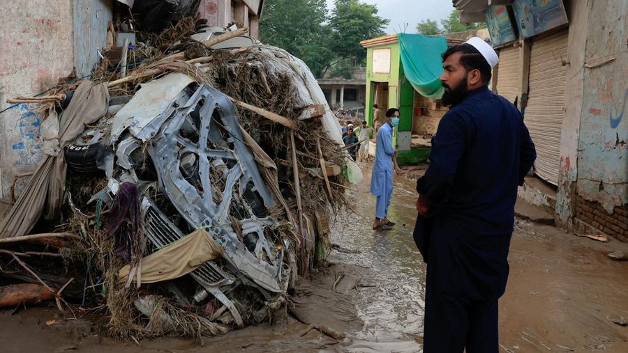 Warga duduk di antara puing-puing rumah yang rusak akibat badai yang menyebabkan hujan lebat dan banjir, di Bayshonai Kalay, distrik Buner, provinsi Khyber Pakhtunkhwa, Pakistan, 17 Agustus 2025. (REUTERS/Akhtar Soomro)