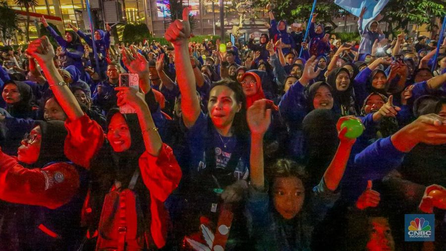 Warga menyaksikan iring-iringan karnaval saat melintas di kawasan Bundaran HI, Jakarta, Minggu (17/8/2025) malam. Acara karnaval ini menjadi pertama kalinya digelar pihak Istana dalam peringatan HUT RI. (CNBC Indonesia/Faisal Rahman)