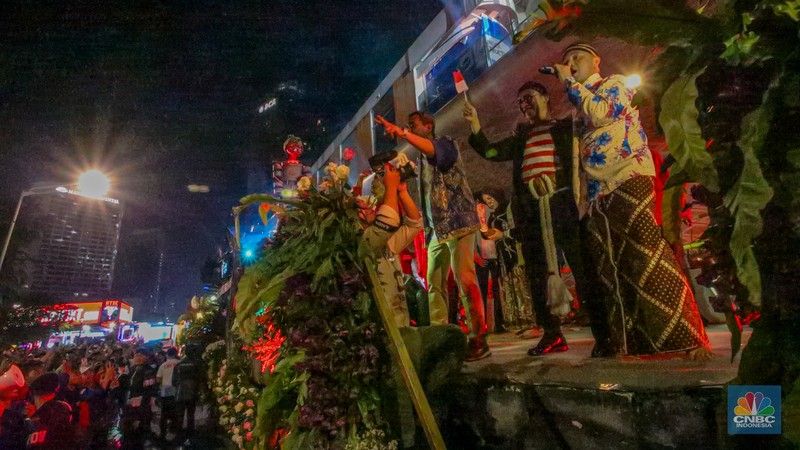 Warga menyaksikan iring-iringan karnaval saat melintas di kawasan Bundaran HI, Jakarta, Minggu (17/8/2025) malam. Warga menyaksikan iring-iringan karnaval saat melintas di kawasan Bundaran HI, Jakarta, Minggu (17/8/2025) malam. Acara karnaval ini menjadi pertama kalinya digelar pihak Istana dalam peringatan HUT RI. (CNBC Indonesia/Faisal Rahman)