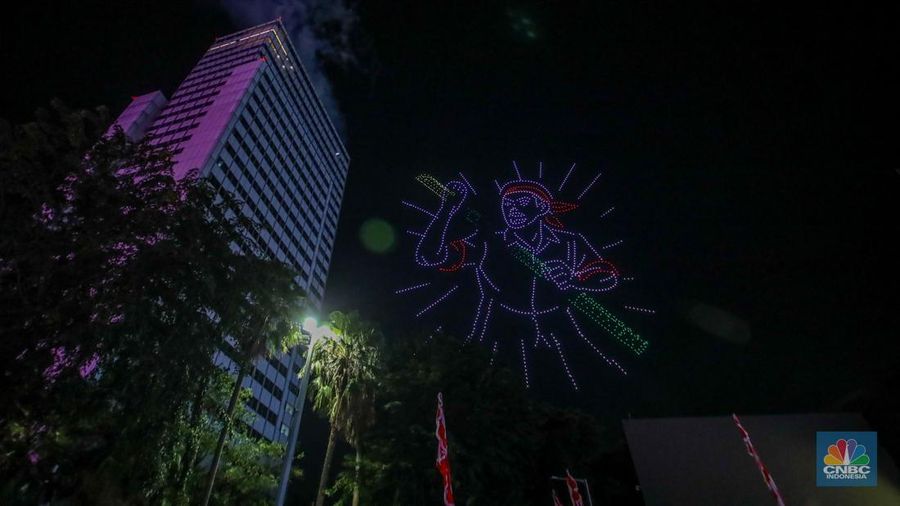Warga menyaksikan iring-iringan karnaval saat melintas di kawasan Bundaran HI, Jakarta, Minggu (17/8/2025) malam. Acara karnaval ini menjadi pertama kalinya digelar pihak Istana dalam peringatan HUT RI. (CNBC Indonesia/Faisal Rahman)