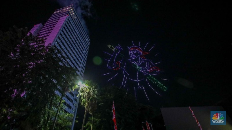 Warga menyaksikan iring-iringan karnaval saat melintas di kawasan Bundaran HI, Jakarta, Minggu (17/8/2025) malam. Acara karnaval ini menjadi pertama kalinya digelar pihak Istana dalam peringatan HUT RI. (CNBC Indonesia/Faisal Rahman)