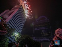 Warga menyaksikan iring-iringan karnaval saat melintas di kawasan Bundaran HI, Jakarta, Minggu (17/8/2025) malam. Acara karnaval ini menjadi pertama kalinya digelar pihak Istana dalam peringatan HUT RI. (CNBC Indonesia/Faisal Rahman)