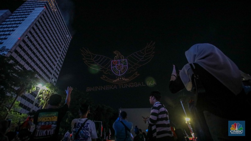 Warga menyaksikan iring-iringan karnaval saat melintas di kawasan Bundaran HI, Jakarta, Minggu (17/8/2025) malam. Warga menyaksikan iring-iringan karnaval saat melintas di kawasan Bundaran HI, Jakarta, Minggu (17/8/2025) malam. Acara karnaval ini menjadi pertama kalinya digelar pihak Istana dalam peringatan HUT RI. (CNBC Indonesia/Faisal Rahman)
