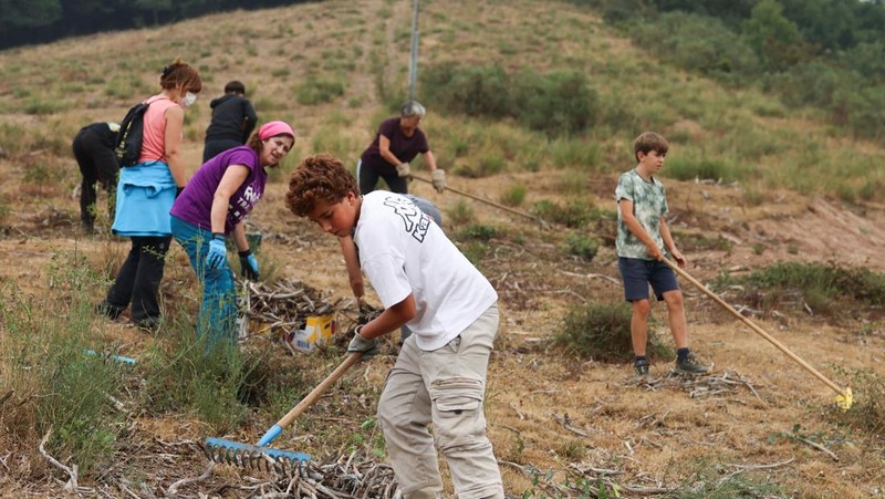 Manuel Carretero, 12, dan penduduk lainnya membersihkan semak-semak dan tumbuhan untuk mencegah kebakaran hutan mencapai desa, di Riano, dekat Leon, Spanyol, 18 Agustus 2025. (REUTERS/Nacho Doce)