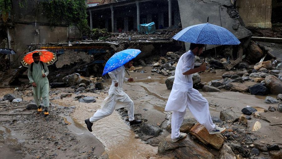Para relawan berjalan sambil membawa payung untuk menghindari hujan saat mereka meninjau daerah yang rusak, menyusul badai yang menyebabkan hujan lebat dan banjir di Bayshonai Kalay, di distrik Buner, di provinsi Khyber Pakhtunkhwa, Pakistan, 18 Agustus 2025. Para relawan berjalan sambil membawa payung untuk menghindari hujan saat mereka meninjau daerah yang rusak, menyusul badai yang menyebabkan hujan lebat dan banjir di Bayshonai Kalay, di distrik Buner, di provinsi Khyber Pakhtunkhwa, Pakistan, 18 Agustus 2025. (REUTERS/Akhtar Soomro)