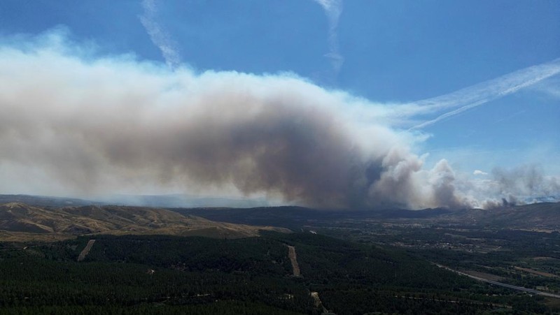Asap mengepul saat helikopter terbang untuk memadamkan kebakaran hutan di pegunungan Oimbra, dekat Verin, di provinsi Ourense, wilayah Galicia, Spanyol, Selasa (19/8/2025). (REUTERS/Nacho Doce)