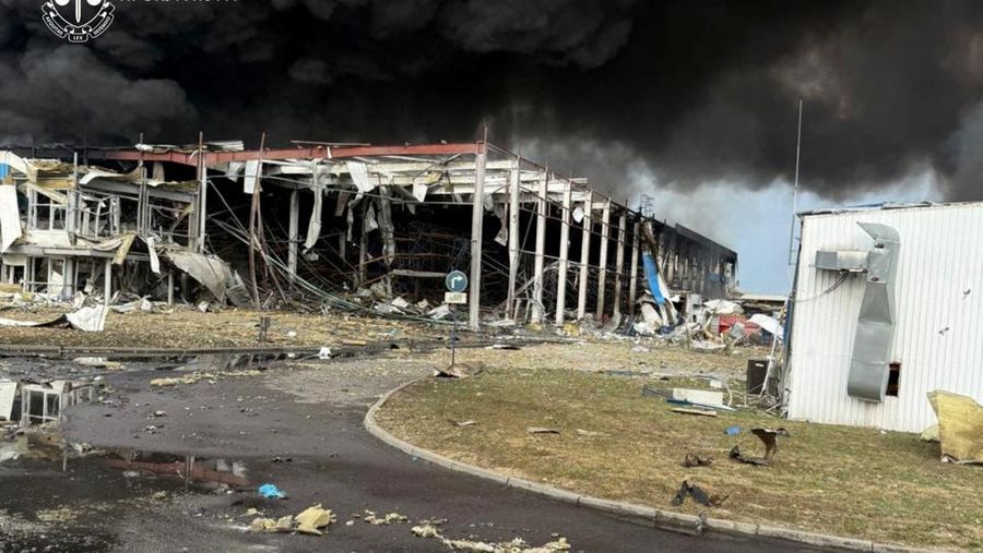 Personel penegak hukum menyaksikan asap mengepul di atas pabrik Flextronics yang terkena serangan rudal Rusia, di tengah serangan Rusia terhadap Ukraina, di Mukachevo, wilayah Zakarpattia, Ukraina, 21 Agustus 2025. (Zakarpattia Regional Prosecutor's Office/Handout via REUTERS)