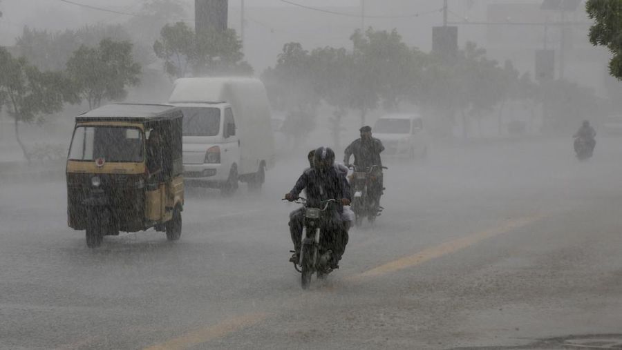 Para komuter bepergian di jalan saat hujan deras di Karachi, Pakistan, 20 Agustus 2025. (REUTERS/Shakil Adil)