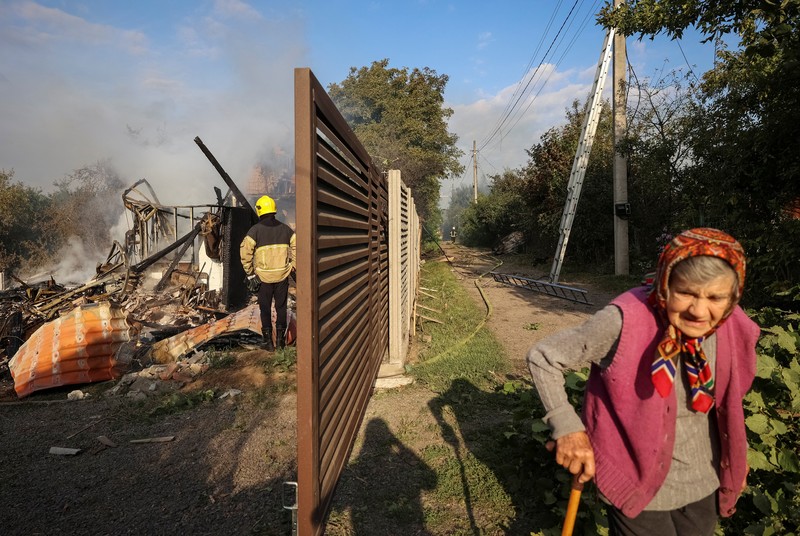 Personel penegak hukum menyaksikan asap mengepul di atas pabrik Flextronics yang terkena serangan rudal Rusia, di tengah serangan Rusia terhadap Ukraina, di Mukachevo, wilayah Zakarpattia, Ukraina, 21 Agustus 2025. (Zakarpattia Regional Prosecutor's Office/Handout via REUTERS)