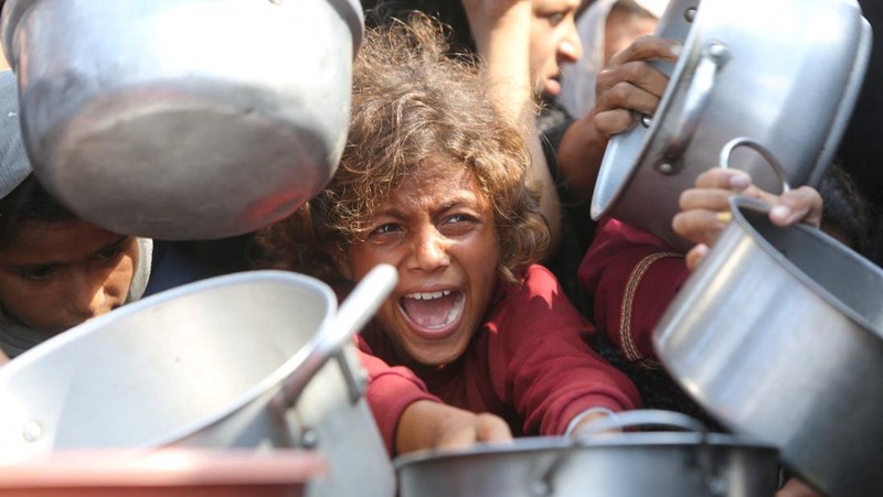 Warga Palestina menunggu untuk menerima makanan dari dapur amal di Khan Younis, Jalur Gaza Selatan, Kamis (21/8/2025). (REUTERS/Hatem Khaled)