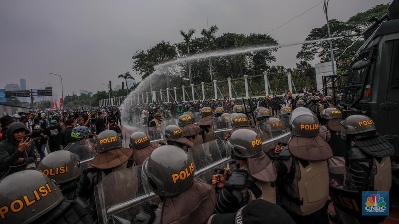 Aparat kepolisian memukul mundur massa demo 25 Agustus di depan kompleks parlemen, Jakarta, dengan menyemprotkan water cannon, Senin (25/8) siang. (CNBC Indonesia/Faisal Rahman)