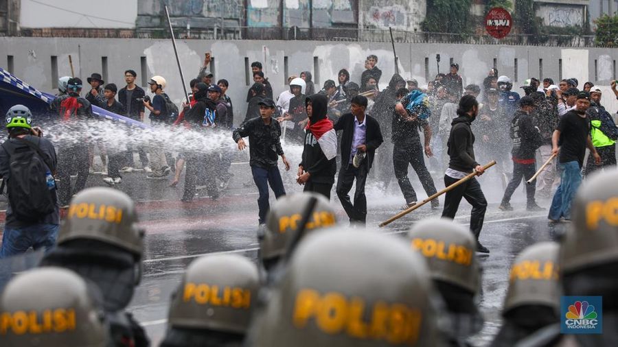 Aparat kepolisian memukul mundur massa demo 25 Agustus di depan kompleks parlemen, Jakarta, dengan menyemprotkan water cannon, Senin (25/8) siang. (CNBC Indonesia/Faisal Rahman)
