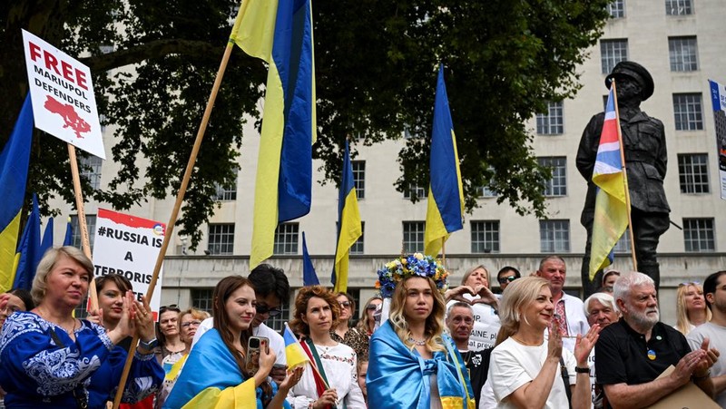 Orang-orang memegang tanda saat diaspora Ukraina berkumpul di Lapangan Kastil Warsawa untuk memperingati Hari Kemerdekaan Ukraina, di Warsawa, Polandia, 24 Agustus 2025. (REUTERS/Kacper Pempel)