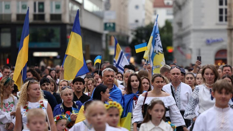 Orang-orang memegang tanda saat diaspora Ukraina berkumpul di Lapangan Kastil Warsawa untuk memperingati Hari Kemerdekaan Ukraina, di Warsawa, Polandia, 24 Agustus 2025. (REUTERS/Kacper Pempel)