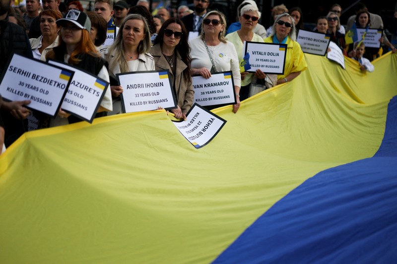Orang-orang memegang tanda saat diaspora Ukraina berkumpul di Lapangan Kastil Warsawa untuk memperingati Hari Kemerdekaan Ukraina, di Warsawa, Polandia, 24 Agustus 2025. Orang-orang memegang tanda saat diaspora Ukraina berkumpul di Lapangan Kastil Warsawa untuk memperingati Hari Kemerdekaan Ukraina, di Warsawa, Polandia, 24 Agustus 2025. (REUTERS/Kacper Pempel)
