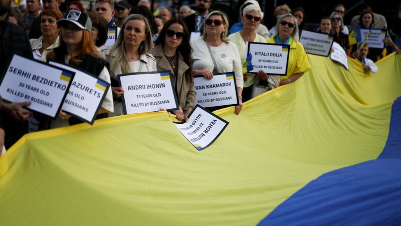 Orang-orang memegang tanda saat diaspora Ukraina berkumpul di Lapangan Kastil Warsawa untuk memperingati Hari Kemerdekaan Ukraina, di Warsawa, Polandia, 24 Agustus 2025. (REUTERS/Kacper Pempel)