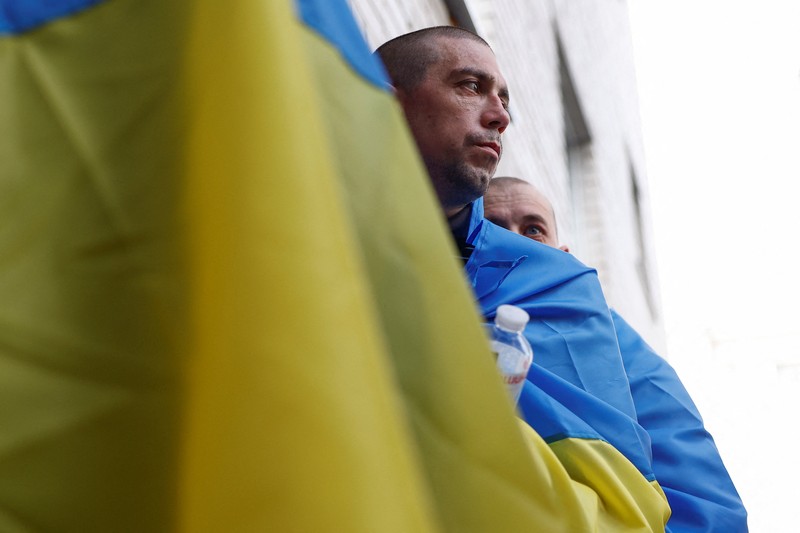 Tahanan perang (POW) Ukraina yang dibebaskan meninggalkan bus setelah pertukaran, di tengah serangan Rusia terhadap Ukraina, di lokasi yang dirahasiakan di Ukraina, 24 Agustus 2025. (REUTERS/Valentyn Ogirenko)
