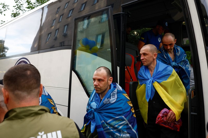 Tahanan perang (POW) Ukraina yang dibebaskan meninggalkan bus setelah pertukaran, di tengah serangan Rusia terhadap Ukraina, di lokasi yang dirahasiakan di Ukraina, 24 Agustus 2025. (REUTERS/Valentyn Ogirenko)