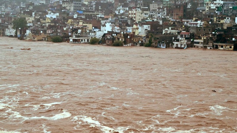 Orang-orang berjalan di jembatan untuk menyeberangi sungai Beas yang meluap setelah hujan lebat di distrik Kullu di negara bagian utara Himachal Pradesh, India, 26 Agustus 2025. (REUTERS/Aqil Khan)