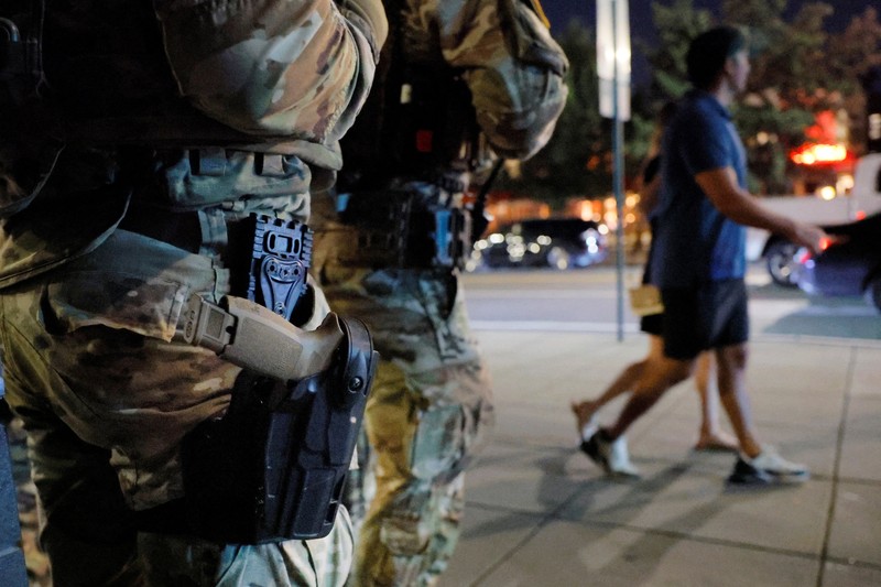 Para perempuan bersepeda saat anggota Garda Nasional, yang membawa senjata api berpatroli di National Mall, beberapa minggu setelah Presiden AS Donald Trump memerintahkan Garda Nasional dan penegak hukum untuk berpatroli di ibu kota negara guna membantu pencegahan kejahatan, di Washington, D.C., AS, 26 Agustus 2025. Para perempuan bersepeda saat anggota Garda Nasional, yang membawa senjata api berpatroli di National Mall, beberapa minggu setelah Presiden AS Donald Trump memerintahkan Garda Nasional dan penegak hukum untuk berpatroli di ibu kota negara guna membantu pencegahan kejahatan, di Washington, D.C., AS, 26 Agustus 2025. (REUTERS/Jose Luis Gonzalez)