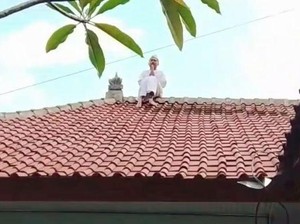 Viral! Pemuda Berpakaian Putih Naik Atap Rumah di Karangasem Bikin Geger
