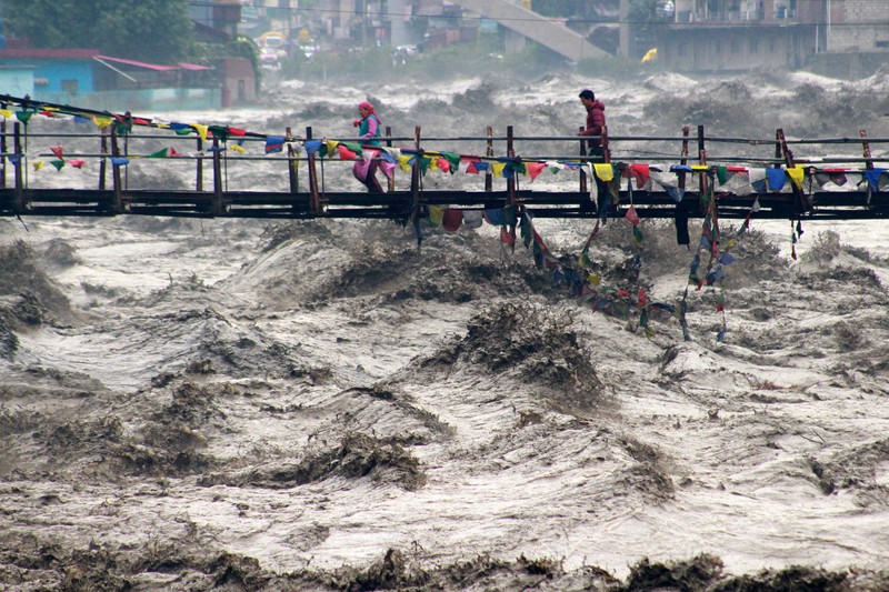 Orang-orang berjalan di jembatan untuk menyeberangi sungai Beas yang meluap setelah hujan lebat di distrik Kullu di negara bagian utara Himachal Pradesh, India, 26 Agustus 2025. Orang-orang berjalan di jembatan untuk menyeberangi sungai Beas yang meluap setelah hujan lebat di distrik Kullu di negara bagian utara Himachal Pradesh, India, 26 Agustus 2025. (REUTERS/Aqil Khan)