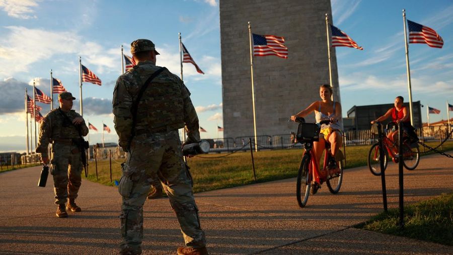 Para perempuan bersepeda saat anggota Garda Nasional, yang membawa senjata api berpatroli di National Mall, beberapa minggu setelah Presiden AS Donald Trump memerintahkan Garda Nasional dan penegak hukum untuk berpatroli di ibu kota negara guna membantu pencegahan kejahatan, di Washington, D.C., AS, 26 Agustus 2025. Para perempuan bersepeda saat anggota Garda Nasional, yang membawa senjata api berpatroli di National Mall, beberapa minggu setelah Presiden AS Donald Trump memerintahkan Garda Nasional dan penegak hukum untuk berpatroli di ibu kota negara guna membantu pencegahan kejahatan, di Washington, D.C., AS, 26 Agustus 2025. (REUTERS/Jose Luis Gonzalez)