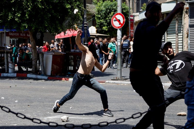 Warga Palestina melempar benda-benda, saat bentrok dengan pasukan Israel, selama serangan Israel di Ramallah, di Tepi Barat yang diduduki Israel, 26 Agustus 2025. (REUTERS/Mohammed Torokman)